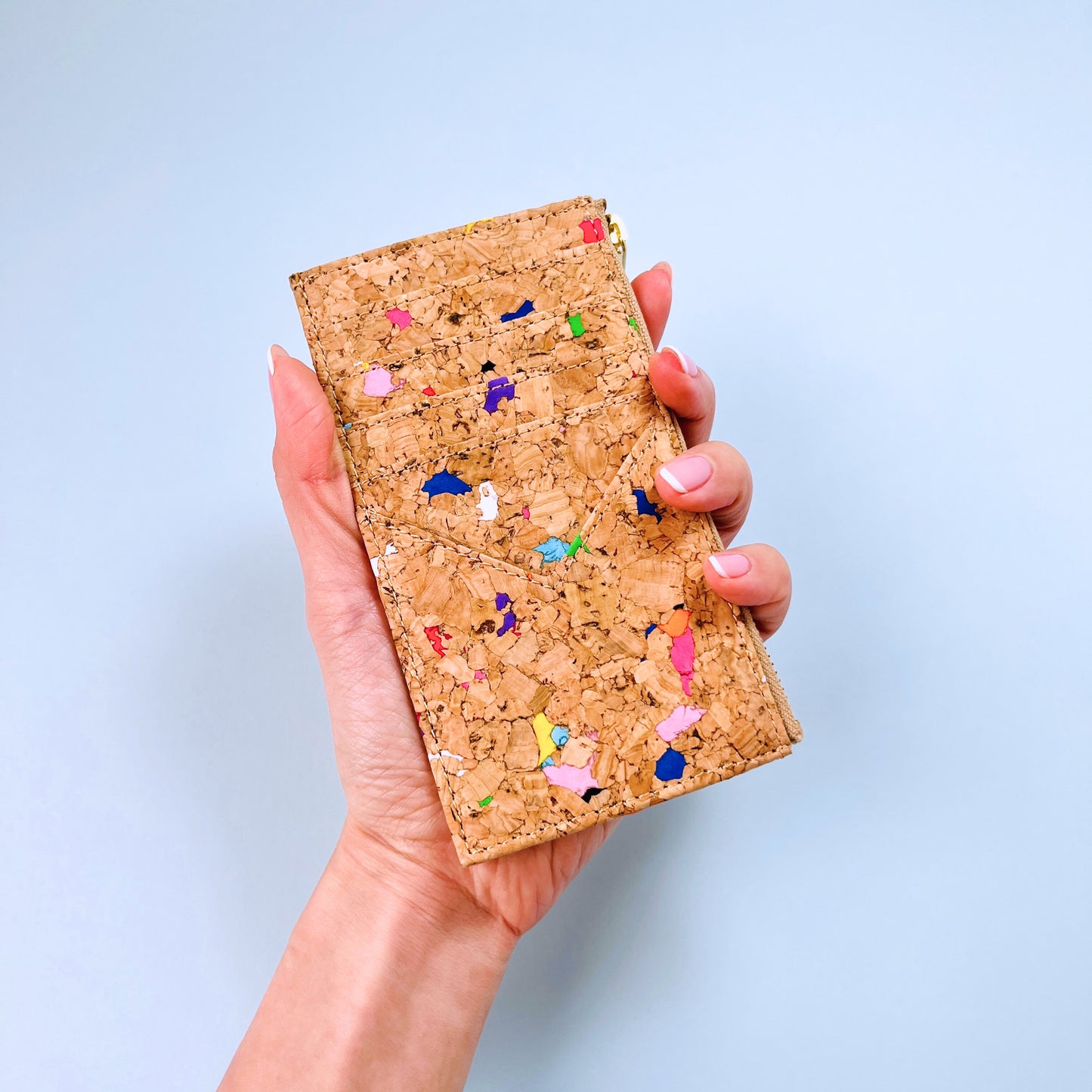 A woman's hand holding By The Sea Collection, Bernie, colourful vegan cork leather card holder