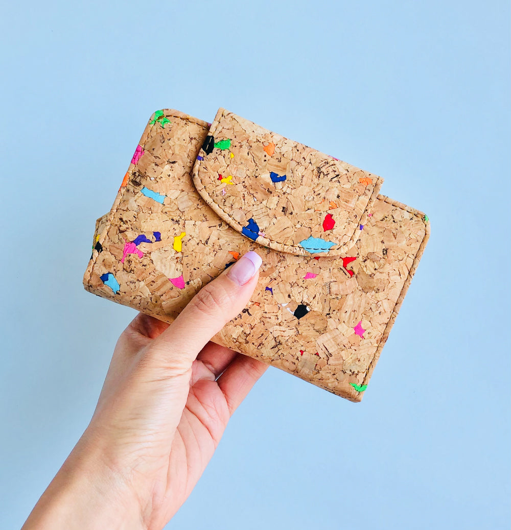 Model holding front of By The Sea Collection, Fiora, colourful vegan cork leather wallet