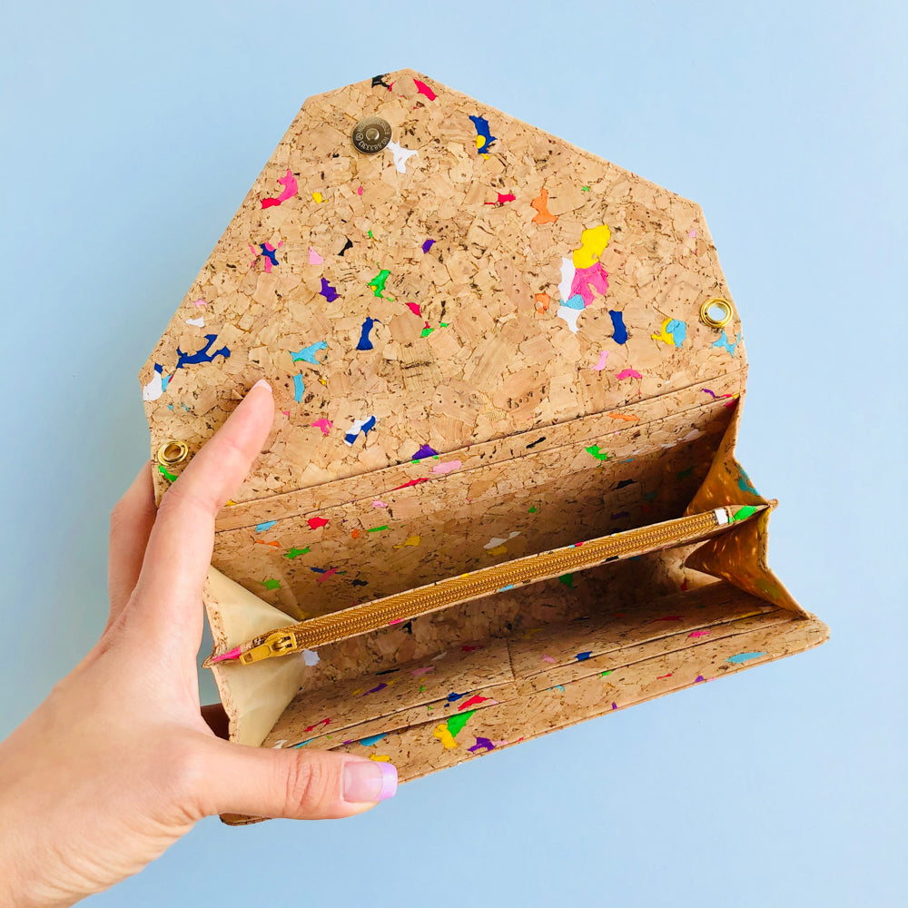 By The Sea Collection, model opening the interior of Flora, colourful vegan cork leather shoulder bag, clutch bag
