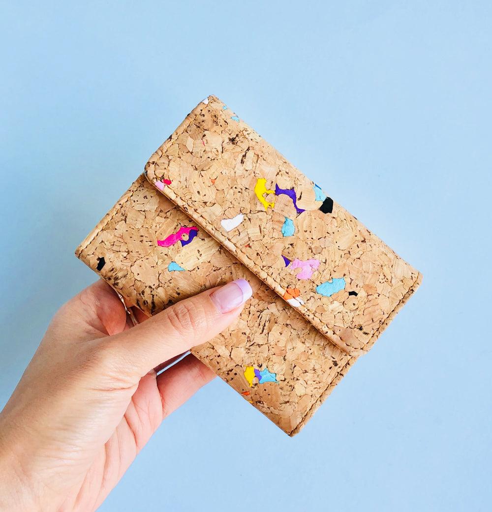 Model holding front side of By The Sea Collection, Laura, colourful vegan cork leather wallet