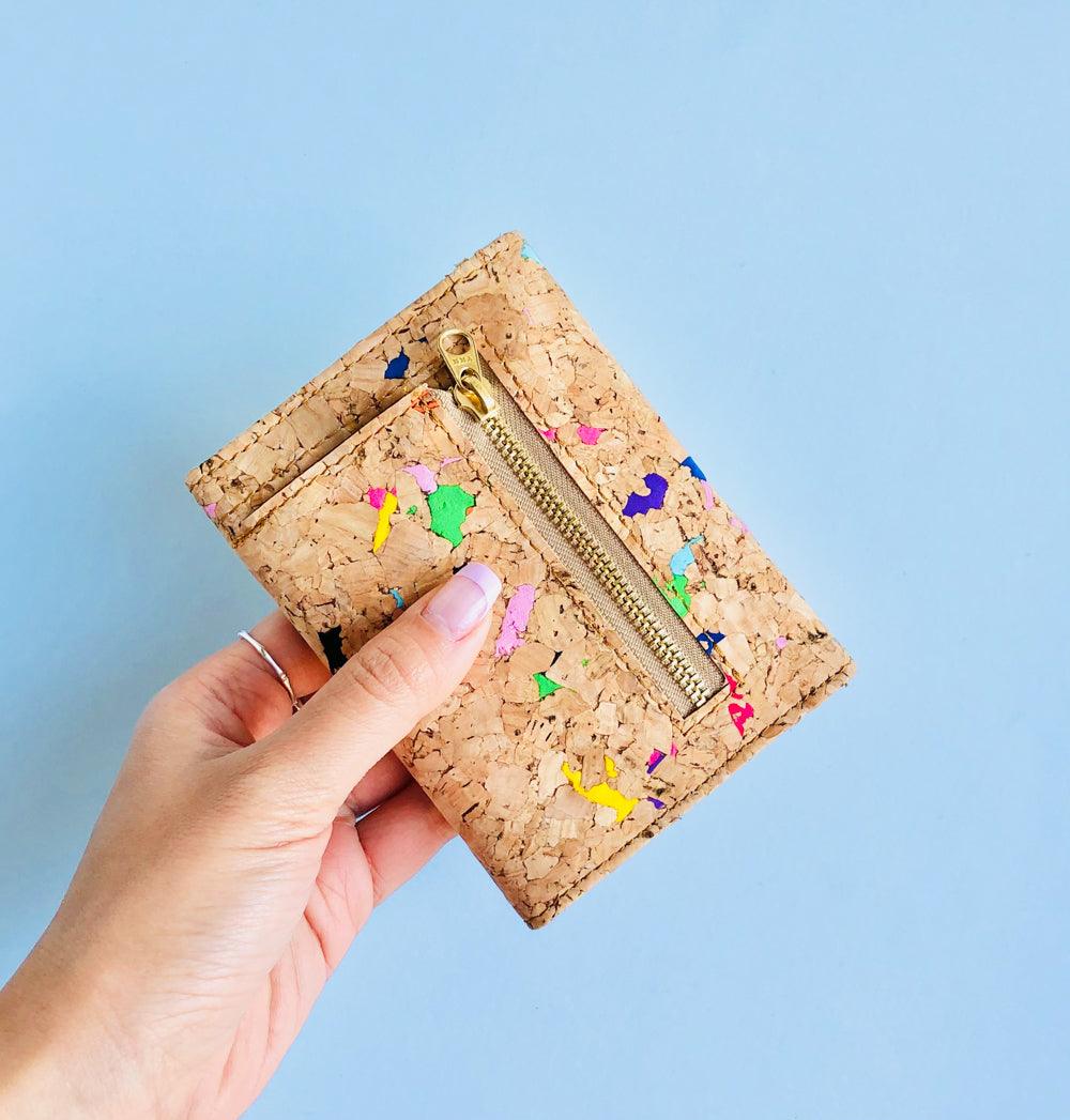 Model holding back side of By The Sea Collection, Laura, colourful vegan cork leather wallet