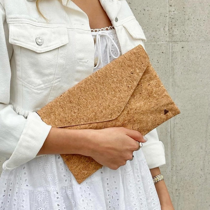 Model in white dress holding as a clutch of By The Sea Collection, Aurora, classic vegan cork leather shoulder bag, clutch bag