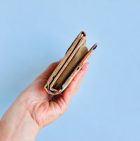 Model holding side view of By The Sea Collection, Fiora, colourful vegan cork leather wallet