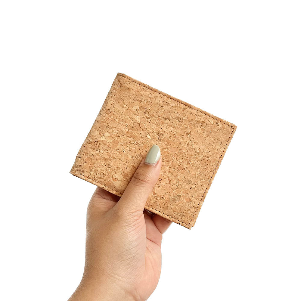 Model hand showing the front of By The Sea Collection, Gilly, classic vegan cork leather compact wallet