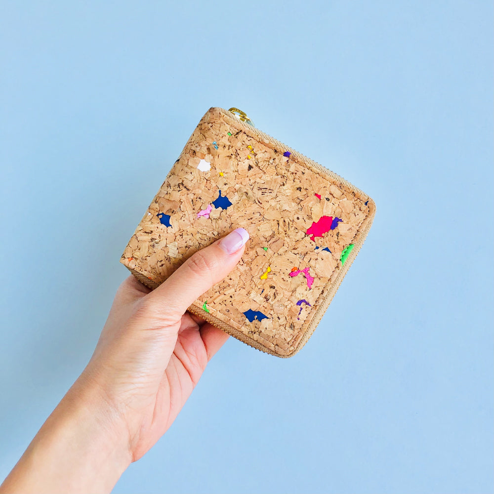 Model holding front side of By The Sea Collection, Ingy, colourful vegan cork leather wallet
