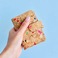 Model holding front side of By The Sea Collection, Kris, colourful vegan cork leather card holder wallet