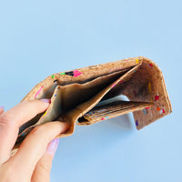 Model holding open bill compartment of By The Sea Collection, Laura, colourful vegan cork leather wallet