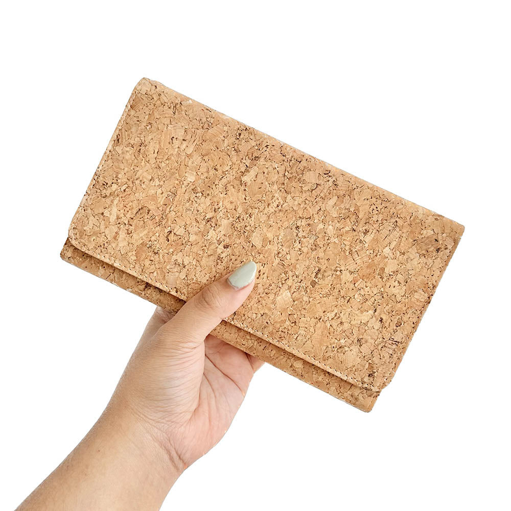 Model hand showing the front of By The Sea Collection, Lyla, classic vegan cork leather clutch
