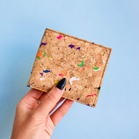 Model hand showing the front of By The Sea Collection, Gilly, colourful vegan cork leather compact wallet